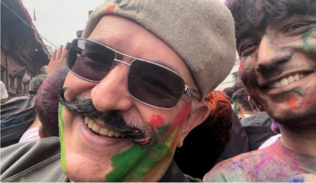 Peter Mousaferiadis in the Holi crowd with face painted
