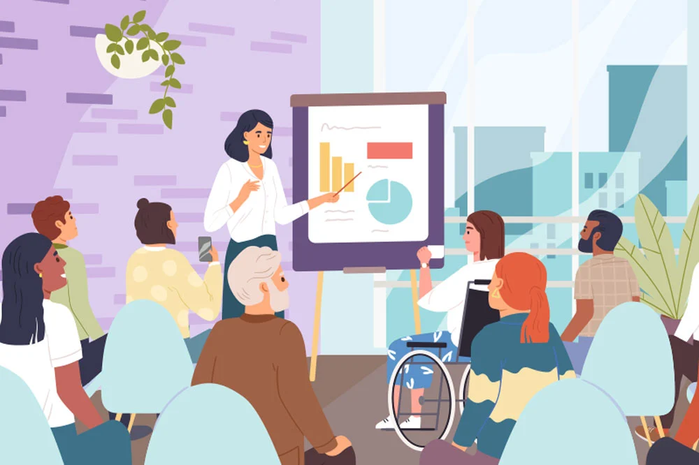 An instructor stands beside a presentation board showing charts while a diverse group of coworkers, including a person using a wheelchair, listen and engage in discussion, reflecting workplace mutuality in a bright, modern office setting